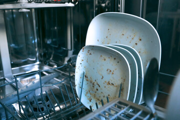 Dirty dishes in dishwashing machine. Making household easy. Technical progress helps keeping clean...
