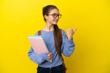 Student kid woman over isolated yellow background pointing to the side to present a product