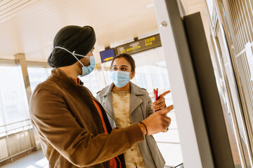 Indian couple wearing face masks buying tickets in airport