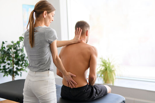 Modern rehabilitation physiotherapy woman worker with man client back treatment