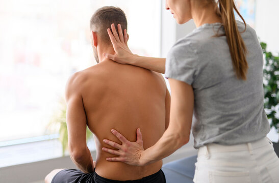 Modern rehabilitation physiotherapy woman worker with man client back treatment