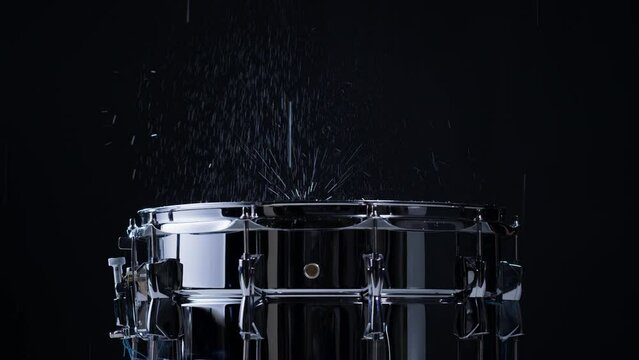 Playing drums with water close-up. Drummer playing musical instrument, professional musician player. 
