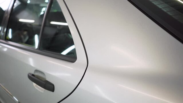 Detailing car. Close-up of the rear fender and the door of a gray car before polishing in the detaling studio.