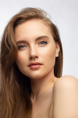 Fototapeta premium Glamour portrait of beautiful woman model with fresh daily makeup and romantic wavy hairstyle. Fashion shiny highlighter on skin, sexy gloss lips make-up and dark eyebrows