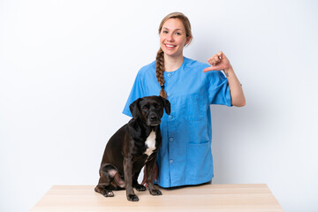 Young veterinarian woman with dog isolated on white background proud and self-satisfied