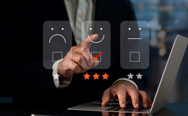 On the virtual screen, a businessman presses the face smiling emoji. Concept for evaluating customer service. User experience or customer satisfaction research can be conducted via a survey, poll.