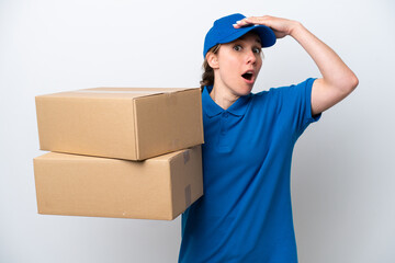 Delivery caucasian woman isolated on white background doing surprise gesture while looking to the...