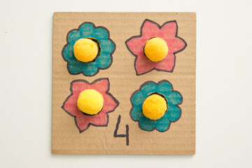 Hand made children home activity from cardboard and pom poms. Early education, Montessori...