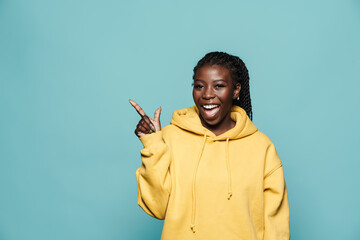 Young black woman smiling and pointing finger aside