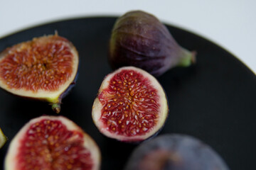 cut figs on a black plate.