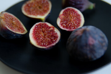 cut figs on a black plate.