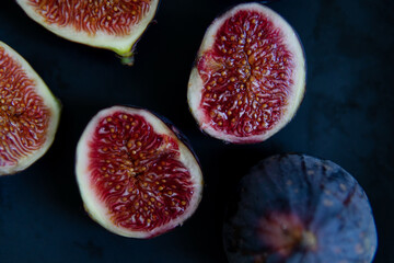 cut figs on a black plate.