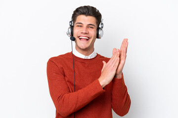Fototapeta premium Telemarketer caucasian man working with a headset isolated on white background applauding after presentation in a conference