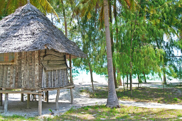 Beautiful typical simple beachfront bamboo wood hut on paradise lonely empty sand beach in shade of...