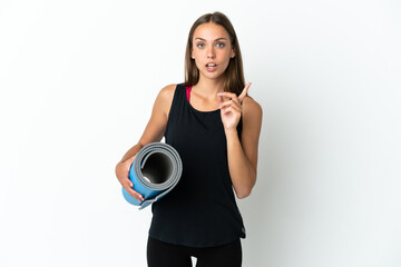 Obraz premium Sport woman going to yoga classes while holding a mat over isolated white background intending to realizes the solution while lifting a finger up
