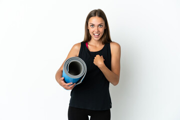 Obraz premium Sport woman going to yoga classes while holding a mat over isolated white background with surprise facial expression