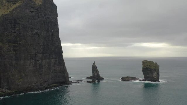 Risinn og Kerlingin Sea Stacks Against Gloomy Sky On The Northern Coast Of The Island Of Eysturoy In Faroe Islands. Aerial Drone Shot