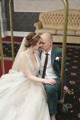 Photo shoot of the bride and groom on a luggage cart at the hotel