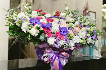 A bouquet of fresh colorful flowers, made up in a wicker basket