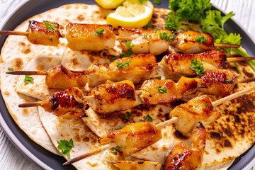 grilled chicken skewers with flatbreads, top view