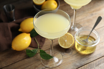 Delicious bee's knees cocktail and ingredients on wooden table