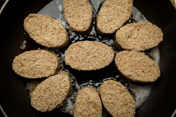 raw chicken cutlets semi-finished products fried in sunflower oil in a pan