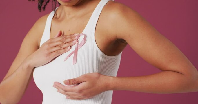 Video of biracial woman touching her pink breast cancer ribbon