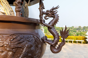 brown dragon statue clinging to the side of the incense burner at Huay Pla Kang Temple Chiang Rai Province, Thailand - obrazy, fototapety, plakaty