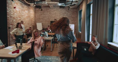 GREAT SUCCESS Camera follows young happy excited businesswoman enter office doing fun winner celebration dance walk.