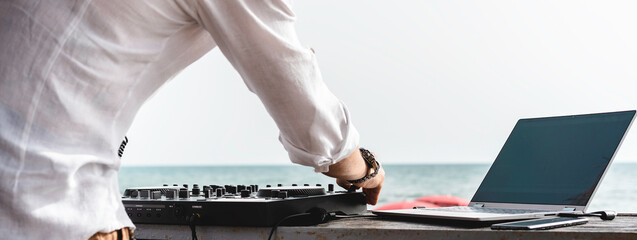 Horizontal banner with disc jockey playing music for tourist people at club party outdoors on the beach - Dj at music live event - Live event, music and fun concept - Entertainment and party concept