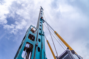 Fototapeta na wymiar lifting boom of a piling machine going up into the sky, bottom view