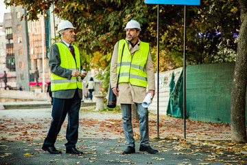 Standing while talking to each other about the plans