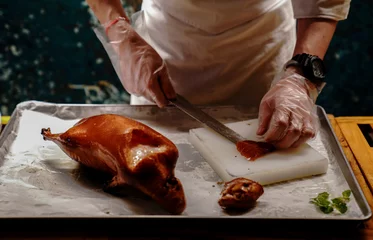 Poster Chinese cook prepares Peking Roast Duck. Peking Duck is a famous duck dish from Beijing that has been prepared since the imperial era, and is now considered one of China's national foods. © Leo Li
