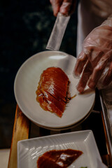 Chinese cook prepares Peking Roast Duck. Peking Duck is a famous duck dish from Beijing that has been prepared since the imperial era, and is now considered one of China's national foods.