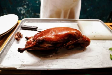 Foto auf Acrylglas Chinese cook prepares Peking Roast Duck. Peking Duck is a famous duck dish from Beijing that has been prepared since the imperial era, and is now considered one of China's national foods. © Leo Li