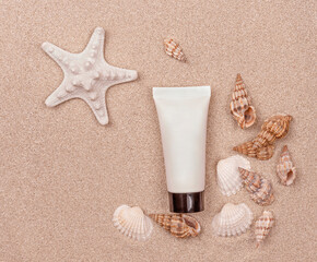 a suntan cream and seashells on sandy background