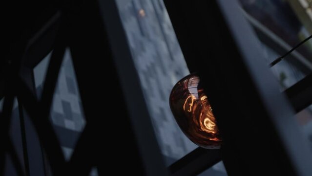 Amber light bulb hanging on a dark room in slow motion. 2K MXF.