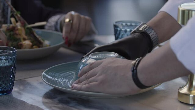 Waiter serving a bowl of rice on the table in front of a customer. At Restaurant Dinning 2K MXF.
