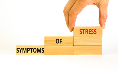 Symptoms of stress symbol. Concept words Symptoms of stress on wooden blocks. Beautiful white table white background. Doctor hand. Psychological business and Symptoms of stress concept. Copy space.