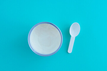 Collagen powder in a jar and a measuring spoon in jar. Blue background. View from above.