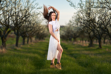 Obraz premium Beautiful woman in a plum orchard in bloom