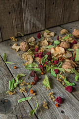 Dried delicious delicacies. Dry pieces of linden, rose hips, pears, raspberries, apples and walnuts snack on a wooden background