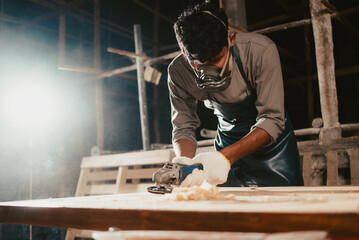 Confident wood worker expert. Young man working at factory. Skilled carpenter cutting a piece of...