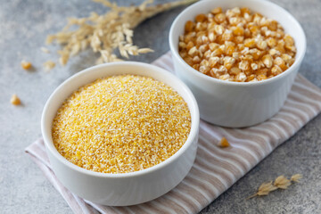 Food and baking gluten-free protein ingredient Сorn flour wholesome and raw corn over gray stone table.