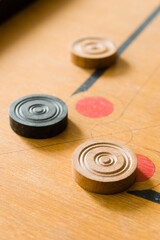 A game of carrom with scattered stones at a corner of the board