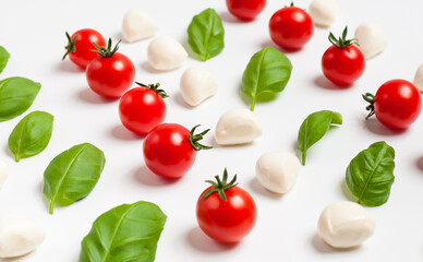 Fresh cherry tomatoes, cherry mozzarella, fresh basil on white background. Selective focus.