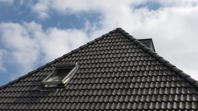 Window in velux style on a roof opens and closes again.
