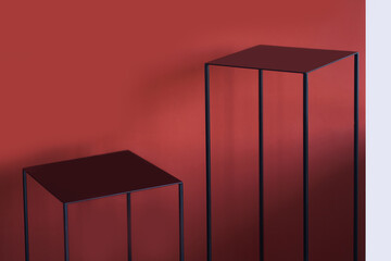 An iron geometric podium on a red background. Stand for product demonstration. High quality photo