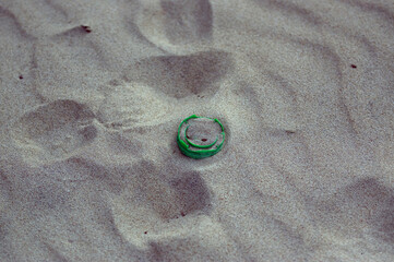 Plastikowe odpadki nakrętka od butelki pozostawiona na plaży.	
 - obrazy, fototapety, plakaty