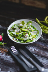Food photography. Green salad with fresh vegetables, asparagus and radishes
